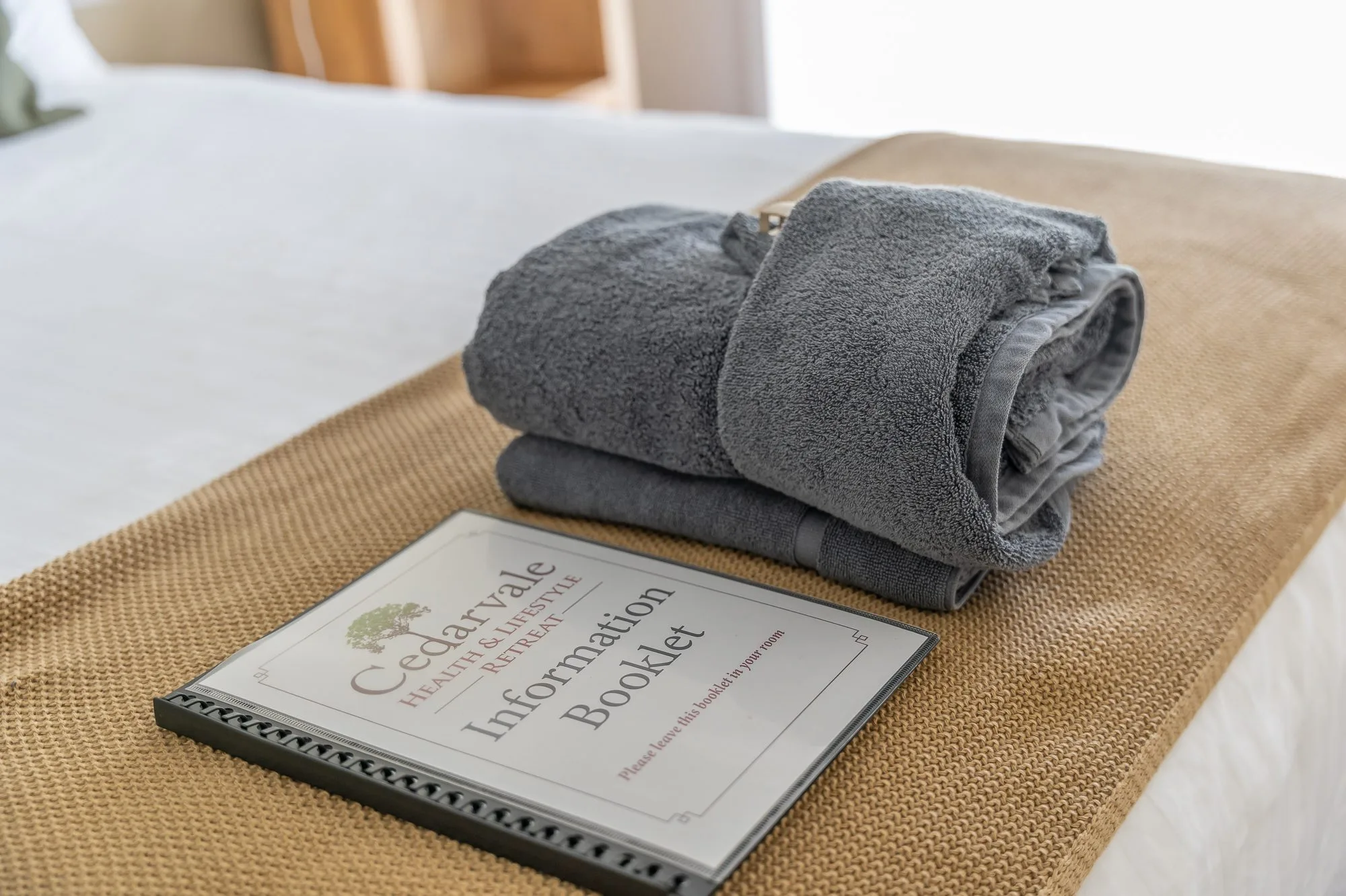Guest bed with Cedarvale information booklet and folded towels