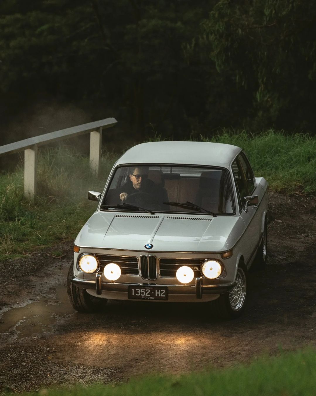 A beautiful white BMW 2002tii, photographed next to the Puffing Billy tourist railway's trestle bridge in Victoria, Australia.