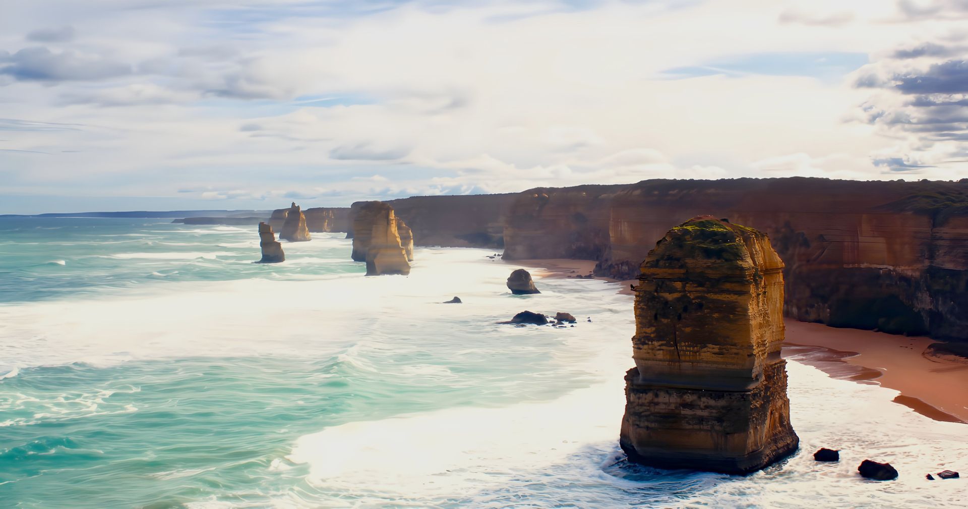 The waves of the Southern Ocean is seen as it reaches the shores of Southern Victoria. From a distance, you can see the 12 apostles, a collection of limestone stacks off the shore of Port Campbell National Park.